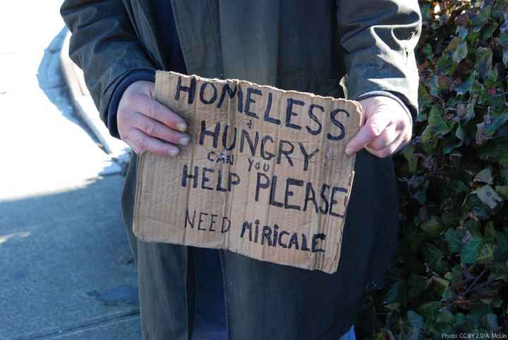 Photo of homeless man holding sign asking for help