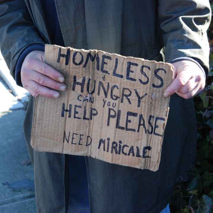 Photo of homeless man holding sign asking for help